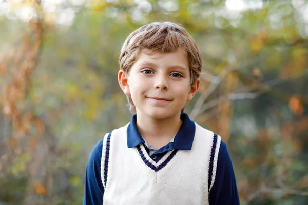 Porträtt av lilla cool unge pojken i skogen. Lyckligt friska barn att ha roligt på varm solig dag tidig höst. Familj, natur, kärlek och aktiv fritid. Grabben i skoluniform. — Stockfoto