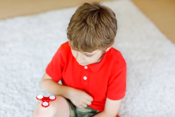 Niño de la escuela jugando con Tri Fidget Hand Spinner en interiores — Foto de Stock