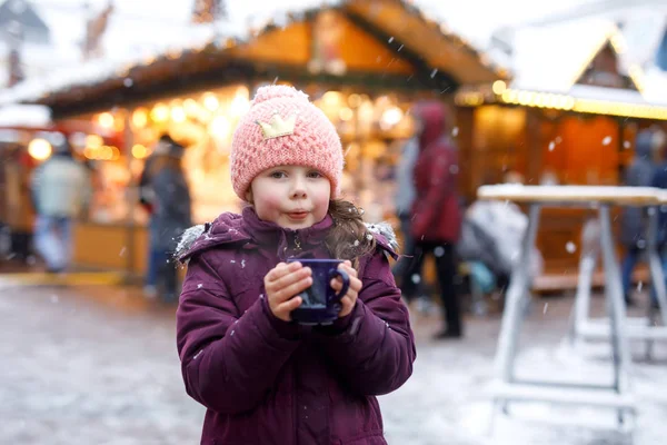 小可爱的女孩与一杯热气腾腾的巧克力或儿童拳。快乐的孩子在圣诞节市场在德国。圣诞节家庭的传统休闲. — 图库照片