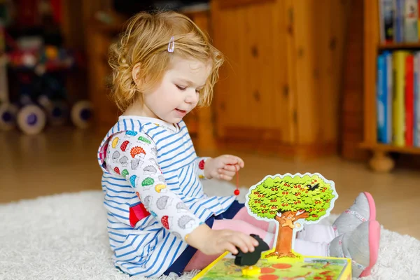 Adorabile carina bambina che gioca con il gioco di attività. Buon bambino sano divertirsi con giocattoli in legno a casa o vivaio . — Foto Stock