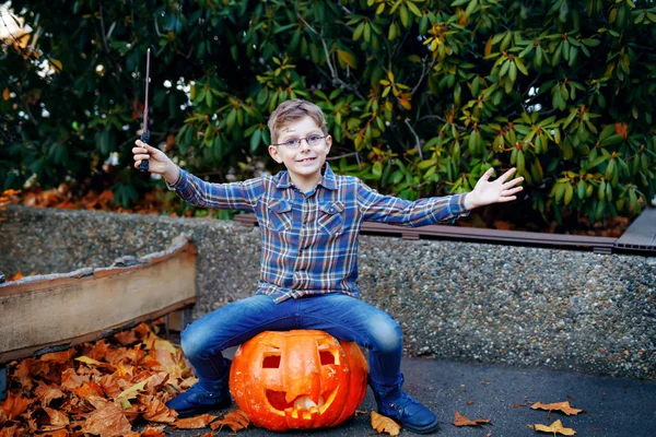 Um miúdo lindo disfarçado de mágico. Criança saudável feliz celebrando Halloween. Menino com óculos ao ar livre no dia de outono . — Fotografia de Stock