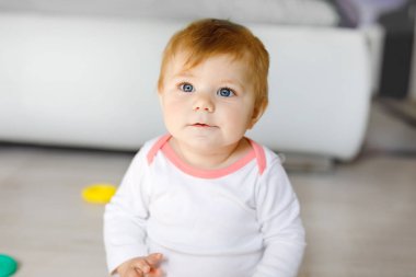 Bebek kız kreş eğitici oyuncaklar ile oynama. Mutlu sağlıklı çocuk evde renkli yumuşak oyuncaklar ile eğleniyor. Evlat plastik piramit inşa etmeye ve harflerle bloğu kullanma