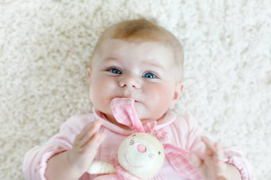 Renkli pastel peluş bunny oyuncakla oynamak sevimli yeni doğmuş bebek. Yeni doğan çocuk, küçük kız kameraya bakıyor. Bebek öğrenme kapmak.