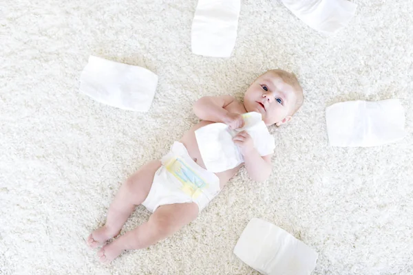 用尿布给3个月大的可爱新生儿喂奶。相貌矮小的女孩或男孩看着摄像机。儿童干性和健康的身体和皮肤概念。幼儿保育. — 图库照片