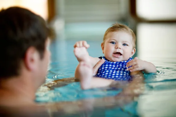 Feliz padre de mediana edad nadando con linda hija adorable en la piscina de hidromasaje. Papá sonriente y niño pequeño, niña de 6 meses divirtiéndose juntos. Vacaciones activas en familia en el hotel spa.. — Foto de Stock