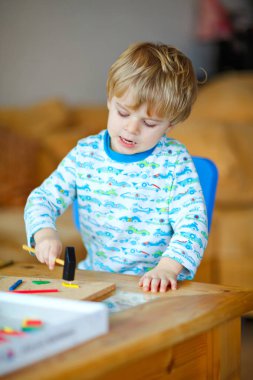 Atölyede ahşap çekiç aracıyla evde oynarken şirin yürümeye başlayan çocuk. Çocuk Çocuk tamirci oynamak. Çocuk Oluşturucusu'nu veya repairer oynarken, onarma veya handcrafting gece elbiseleri. Handcrafting kavramı.