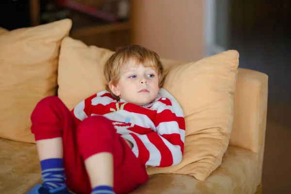 Glad bedårande kid boy titta på TV liggandes. Rolig friskt barn njuter av karikatyrerna. Missbruk-konceptet. Småbarn ser visar och film på tv hemma. — Stockfoto