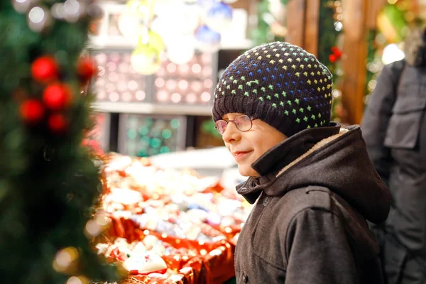 Little cute kid boy selecting decoration on Christmas market. Beautiful child shopping for toys and decorative ornaments — Stock Photo, Image