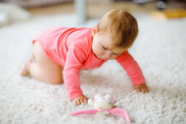 Niña linda aprendiendo a gatear. Niño sano arrastrándose en la habitación de los niños con juguetes de colores. Vista trasera de las piernas del bebé. Lindo niño descubriendo el hogar y aprendiendo diferentes habilidades —  Fotos de Stock