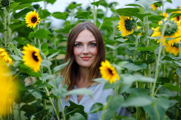 Gyönyörű fiatal nő, ami a smartphone a csokor virág a napraforgó mező selfie. Boldog lány nyári naplemente napon. — Stock Fotó