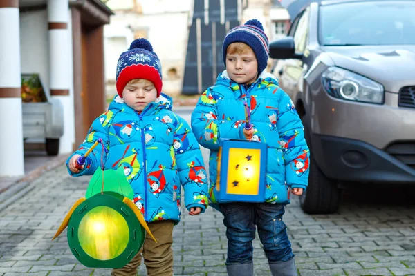 Zwei kleine Jungen mit selbstgebastelten Laternen für einen Halloween oder Martinszug. Schöne Brüder, süße Geschwister, die sich über Kinder und Familienumzug im Kindergarten freuen. deutsche Tradition — Stockfoto