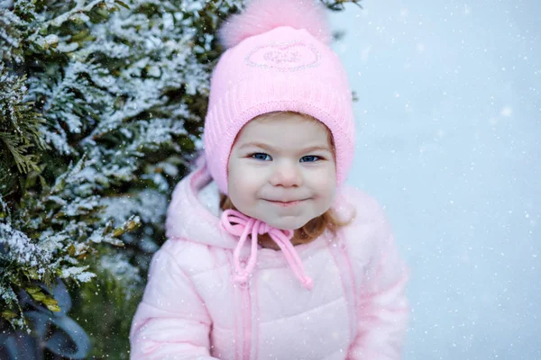 可爱的小女孩冬天在户外散步 可爱的幼儿吃甜棒棒糖 孩子们在寒冷的雪天玩得很开心 穿着保暖的婴儿粉红衣服 头戴有泡泡的帽子 — 图库照片