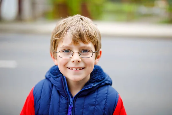 Porträt eines kleinen Jungen mit Brille in farbenfroher Herbstkleidung. glückliches gesundes Kind, das Spaß im Freien hat. Netter Schuljunge lächelt und lacht — Stockfoto