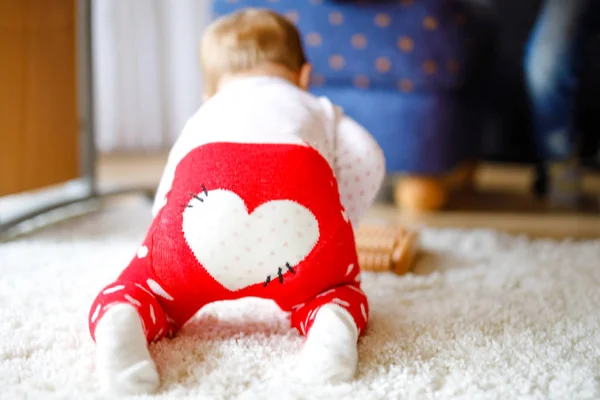 Niña linda aprendiendo a gatear. Niño sano arrastrándose en la habitación de los niños con juguetes de colores. Vista trasera de las piernas del bebé. Lindo niño descubriendo el hogar y aprendiendo diferentes habilidades —  Fotos de Stock