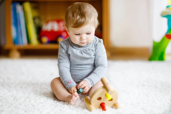 En söt liten flicka som leker med pedagogiska leksaker. Glad frisk barn att ha kul med färgglada olika trä leksak hemma. Tidig utveckling för barn med naturleksak. — Stockfoto