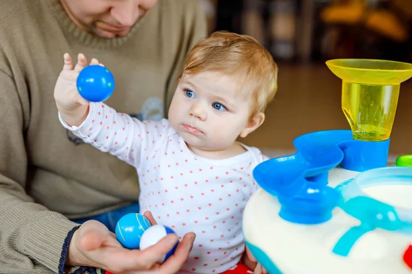 Felice orgoglioso giovane padre divertirsi con la figlia del bambino, ritratto di famiglia insieme. Papà giocare con la bambina con educativo sorter giocattolo con diverse palle colorate. Uomo con bambino a casa . — Foto Stock