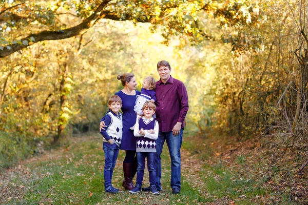 Porträtt av unga föräldrar med tre barn. Mor, far, två barn bröder pojkar och liten söt småbarn syster flicka har roligt tillsammans i höstskogen. Lycklig familj på fem — Stockfoto