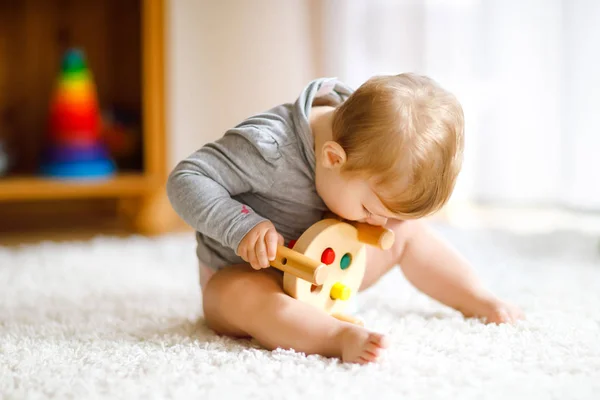 En söt liten flicka som leker med pedagogiska leksaker. Glad frisk barn att ha kul med färgglada olika trä leksak hemma. Tidig utveckling för barn med naturleksak. — Stockfoto