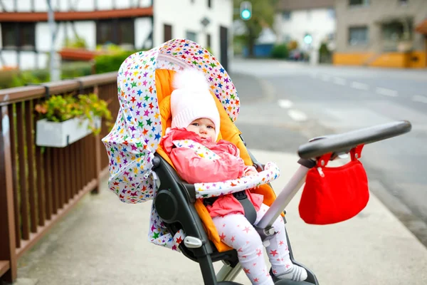 秋天的一天 可爱的小女孩坐在婴儿车或婴儿车里 健康快乐的孩子穿着保暖的衣服在新鲜空气中散步 黄色的秋天枫树 五彩缤纷 — 图库照片