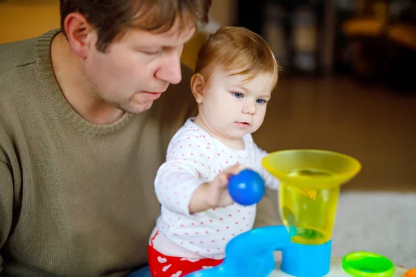 Happy proud young father having fun with baby daughter, family portrait together. Dad playing with baby girl with educational sorter toy with different colorful balls. Man with little child at home. — Stock Photo, Image
