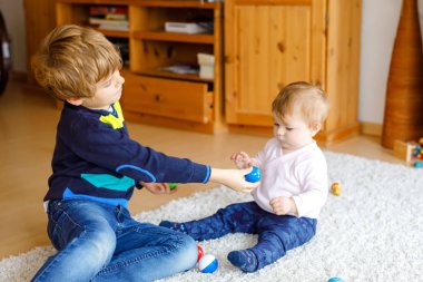 Şirin Bebek kız, sevimli kız kardeşi olan mutlu küçük çocuk çocuk. Kardeşler. Kız ve erkek birlikte oynayan bebek. Büyük çocuk gösteren bebek ahşap pyramide yapma. Aile ve aşk