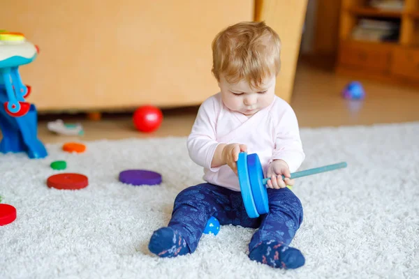 Adorable petite fille jouant avec des jouets éducatifs. Heureux enfant en bonne santé s'amuser avec différents jouets en bois colorés à la maison. Développement précoce pour les enfants avec jouet nature. — Photo