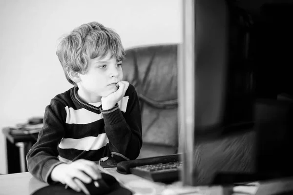 Un niño haciendo deberes escolares en un cuaderno de computadoras. Feliz niño sano buscando información en Internet. Nueva educación mediática, niño viendo lecciones de aprendizaje en la PC. Aula virtual . —  Fotos de Stock