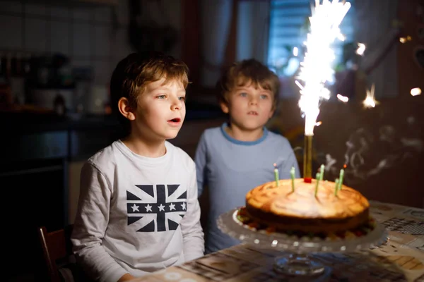 Deux beaux enfants, des petits garçons d'âge préscolaire célébrant leur anniversaire et soufflant des bougies — Photo
