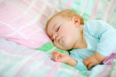 Sevimli küçük kız yatakta uyuyor. Sakin, huzurlu bir çocuk gündüz uykusunda rüya görüyor. Ebeveyn yatağında güzel bir bebek. Yatma kavramı.