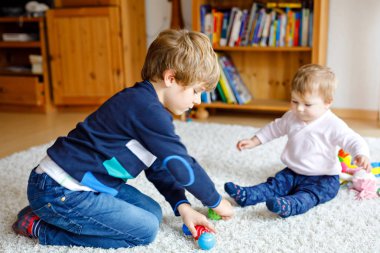 Şirin Bebek kız, sevimli kız kardeşi olan mutlu küçük çocuk çocuk. Kardeşler. Kız ve erkek birlikte oynayan bebek. Büyük çocuk gösteren bebek ahşap pyramide yapma. Aile ve aşk