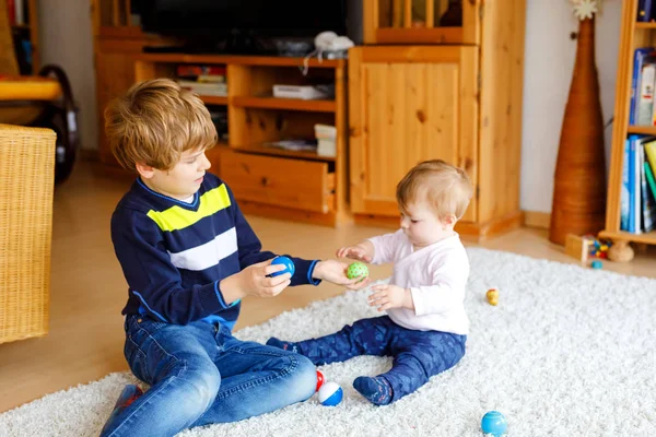 Ragazzino felice con bambina carina, sorella carina. Fratelli e sorelle. Fratello e bambino che giocano insieme. Bambino più grande mostrando bambino facendo piramide di legno. Famiglia e amore — Foto Stock