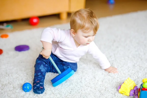 Adorable niña jugando con juguetes educativos. Feliz niño sano que se divierte con colorido juguete de madera diferente en casa. Desarrollo temprano para niños con juguete natural. — Foto de Stock