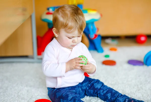 Eğitici oyuncaklarla oynayan sevimli bir kız bebek. Mutlu sağlıklı çocuk evde renkli tahta oyuncaklarla eğleniyor. Doğa oyuncağı olan çocuklar için erken gelişim. — Stok fotoğraf