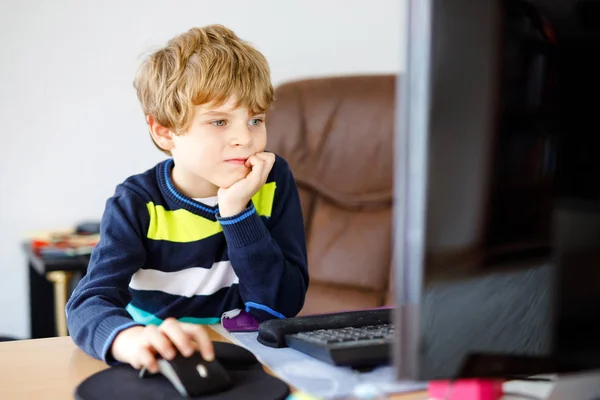 Un niño haciendo deberes escolares en un cuaderno de computadoras. Feliz niño sano buscando información en Internet. Nueva educación mediática, niño viendo lecciones de aprendizaje en la PC. Aula virtual . — Foto de Stock