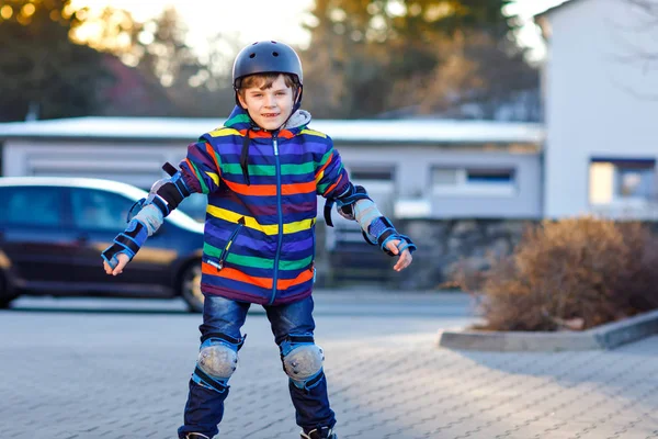かわいい学校の子供男の子市ローラー スケートします。ローラー スケート保護安全服で幸せな健康な子。アクティブな少年スポーツを作るとインライン スケート スケート学習. — ストック写真
