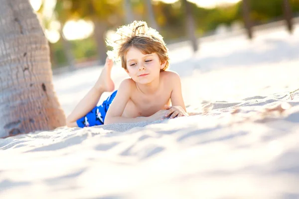 Blonder kleiner Junge mit spass am miami beach, key biscayne. glücklich gesundes nettes Kind, das mit Sand spielt und in der Nähe des Ozeans läuft. Palmen, Sicherheitshaus und weißer Sand. mit sonnig warmem, hellem Licht — Stockfoto