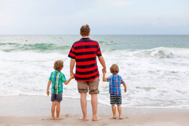 İki mutlu küçük çocuk okyanus sahilinde durup fırtınalı bir günde ufka bakıyorlar. Aile, baba ve tatlı oğullar tatil yapıyor, hayal kuruyor ve yazın tadını çıkarıyorlar.