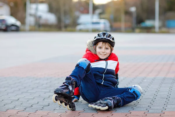 Chłopak ze szkoły jeździ na rolkach po mieście. dziecko w ubraniu ochronnym. Aktywny uczeń uprawiający sport i uczący się jeździć na wrotkach. Upadek i zranienie — Zdjęcie stockowe