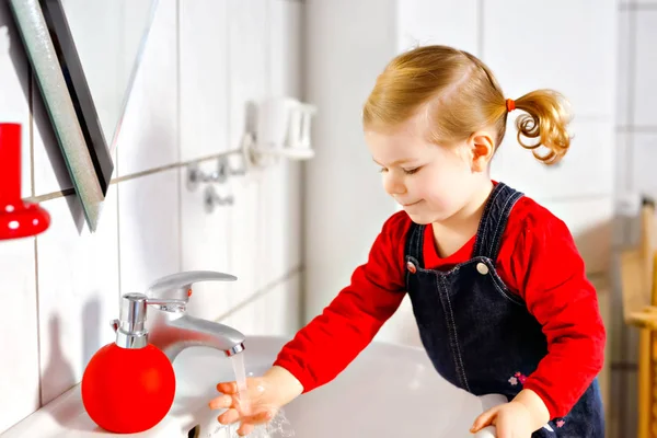 Menina da criança bonito lavar as mãos com sabão e água no banheiro. Adorável criança aprendendo a limpar partes do corpo. Rotina de higiene matinal. Criança saudável feliz em casa ou no berçário . — Fotografia de Stock