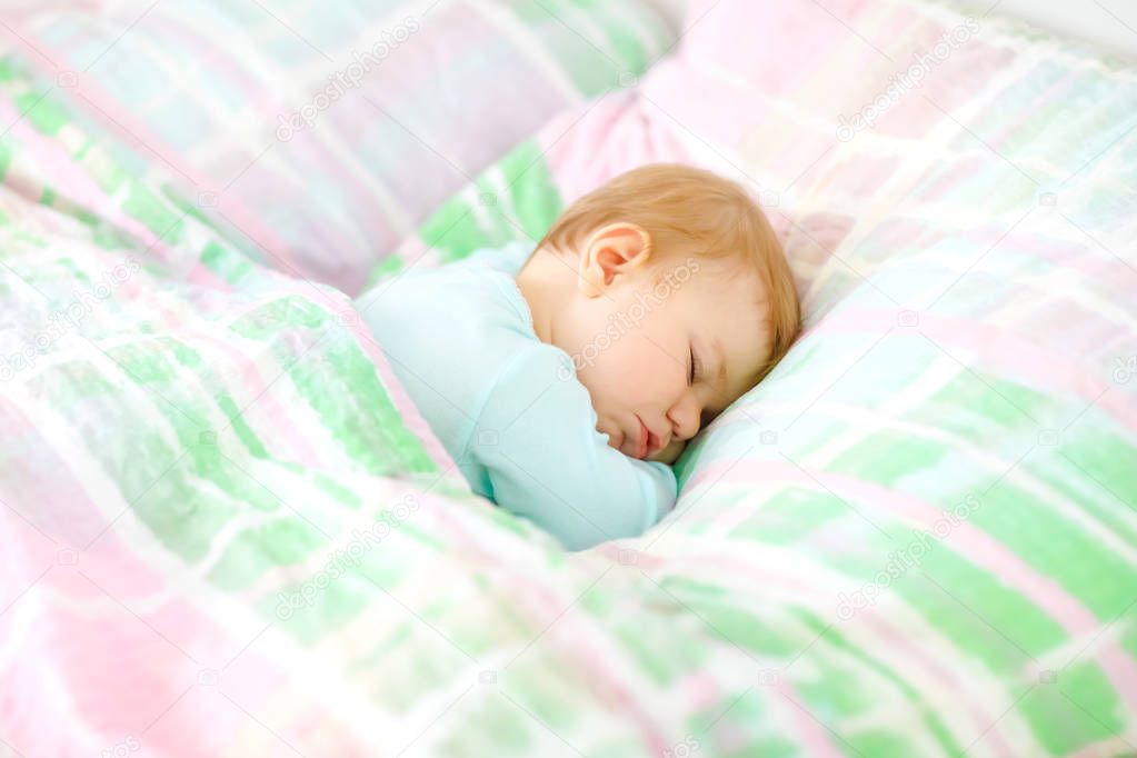 Adorable little baby girl sleeping in bed. Calm peaceful child dreaming during day sleep. Beautiful baby in parents bed. Sleeping together concept.