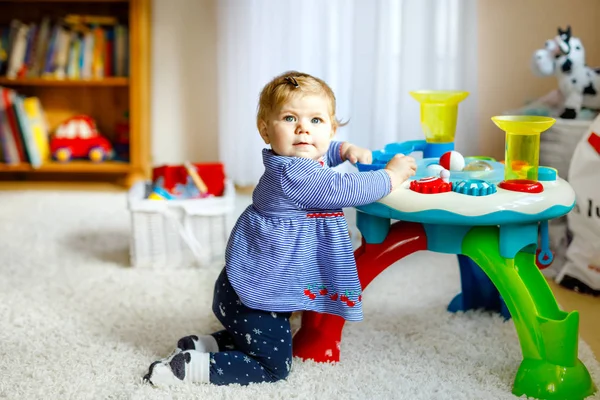 Schattig leuk mooie babymeisje spelen met de educatief speelgoed thuis of kwekerij. Gelukkig gezond kind plezier met kleurrijke verschillende speelgoed. Kind leren verschillende vaardigheden. — Stockfoto