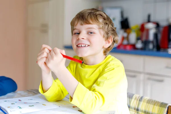 可爱的孩子在家里做家庭作业的肖像。小集中的孩子用五颜六色的铅笔写作, 室内。小学和教育。学习写信和数字的孩子. — 图库照片