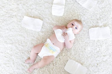 3 güveli ve bebek bezli şirin bir bebek. Minik kız ya da çocuk kameraya bakıyor. Çocuk konsepti için kuru ve sağlıklı vücut ve deri. Bebek odası..