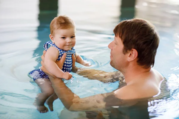 Feliz padre de mediana edad nadando con linda hija adorable en la piscina de hidromasaje. Papá sonriente y niño pequeño, niña de 6 meses divirtiéndose juntos. Vacaciones activas en familia en el hotel spa — Foto de Stock