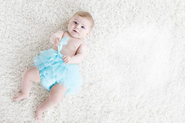 Adorable baby girl on white background wearing turquoise tutu skirt. Cute little child laughing and smiling. Happy carefree baby. Childhood, new life concept — Stock Photo, Image