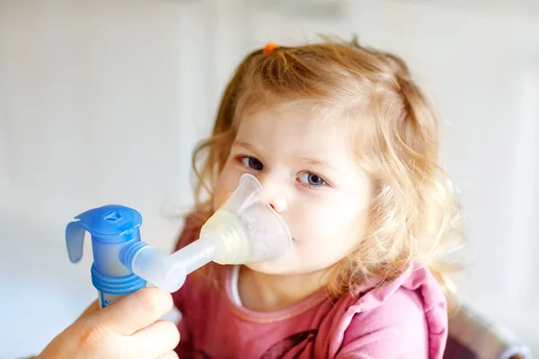 Pequeña niña haciendo inhalación con nebulizador en casa. Padre o madre ayudando y sosteniendo el dispositivo. Niño con gripe, tos y bronquitis. inhalador de asma inhalación vapor concepto enfermo —  Fotos de Stock