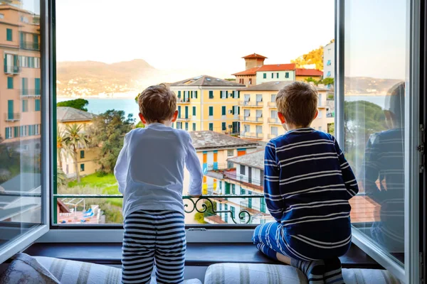 Δύο μικρά παιδιά απολαμβάνουν θέα από το παράθυρο το πρωί στην περιοχή της Λιγουρίας στην Ιταλία. Καταπληκτικά χωριά Τσίνκουε Τέρε και Πορτοφίνο. Οικογενειακές διακοπές σε όμορφη ιταλική πόλη με πολύχρωμα σπίτια. — Φωτογραφία Αρχείου