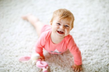 Küçük şirin bebek kız tarama öğrenme. Sağlıklı çocuk çocuk odası renkli oyuncaklar ile kaynıyor. Bebek bacakları arkadan görünüm. Ana sayfa keşfetmek ve farklı becerileri öğrenme şirin bebek