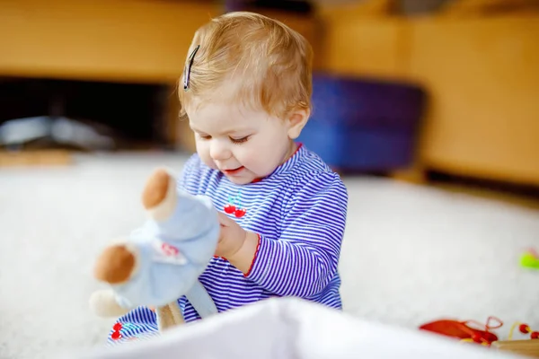 Bayi perempuan cantik yang manis bermain dengan mainan pendidikan di rumah atau di kamar bayi. Anak yang sehat bersenang-senang dengan mainan yang berbeda warna-warni. Anak belajar keterampilan yang berbeda . — Stok Foto
