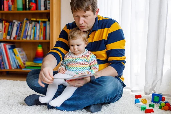年轻的父亲阅读书与他可爱可爱的宝贝女儿女孩 — 图库照片